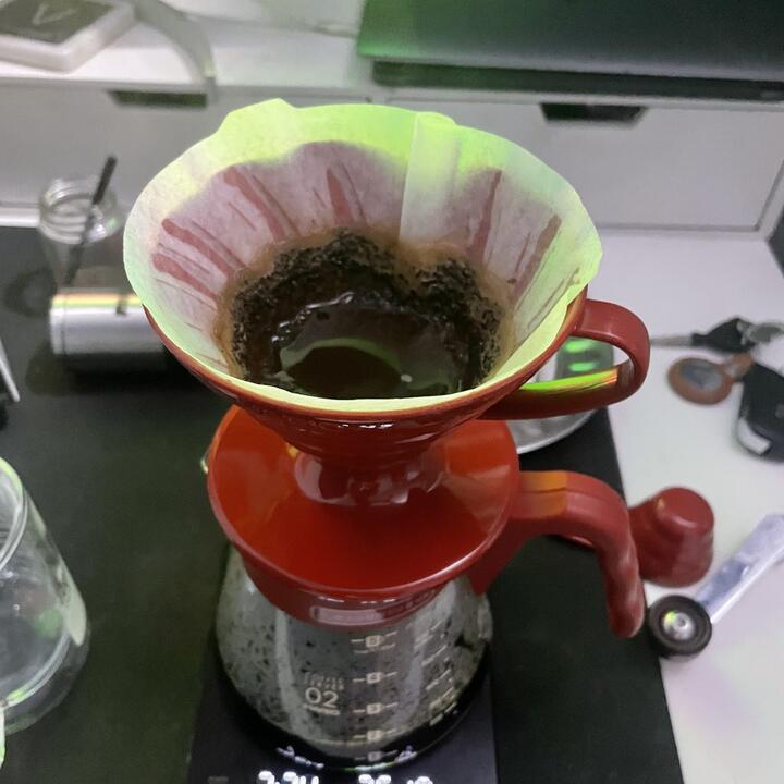 赤いドリッパーと計量器でコーヒーを抽出している様子