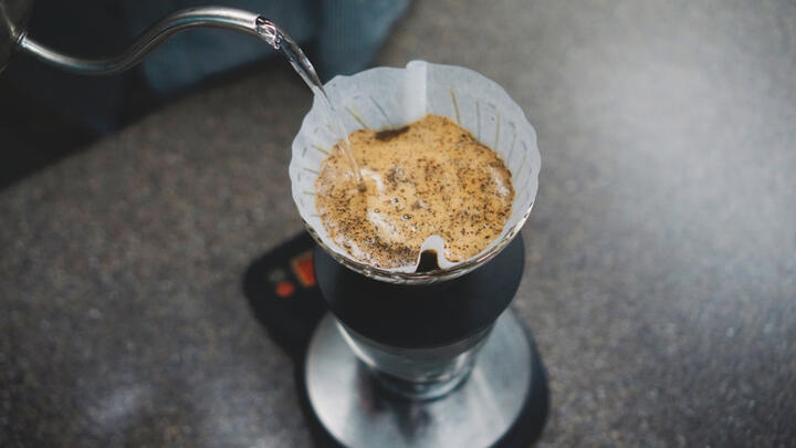 ドリッパーへ細く湯を注いでコーヒーを淹れる手元