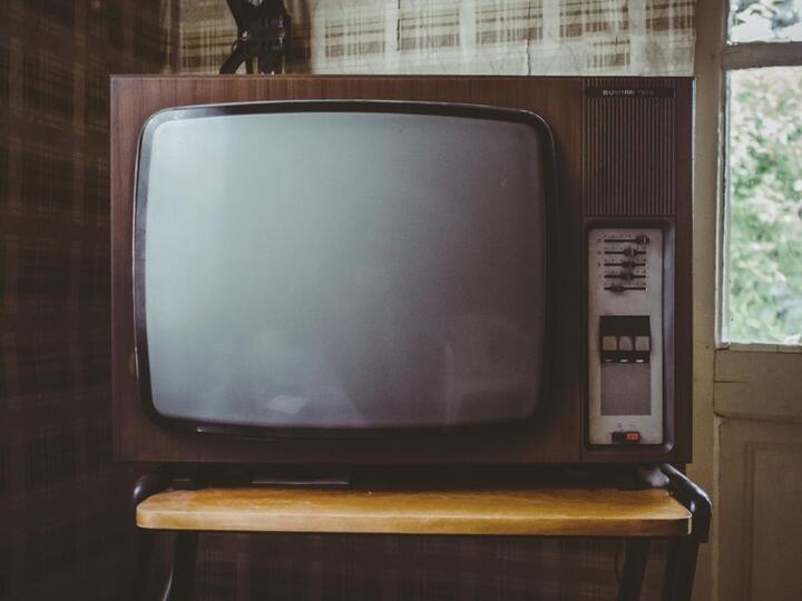 木の台の上に置かれた古いブラウン管テレビ
