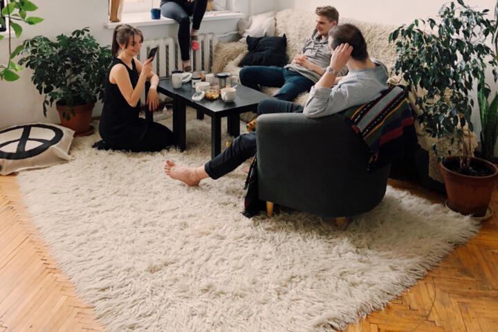 明るい部屋で椅子に座り会話する三人